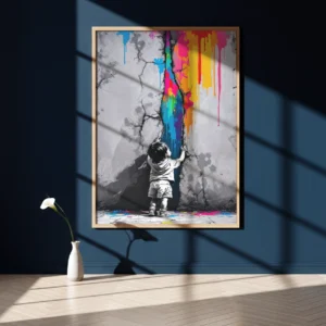 Affiche encadrée d’un enfant face à une fissure colorée sur mur bleu foncé, éclairée par l’ombre d’une fenêtre, avec vase blanc posé au sol sur parquet clair.