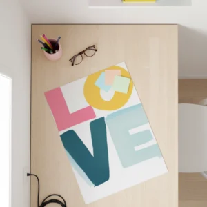 affiche love pastel posée sur bureau minimaliste en bois clair