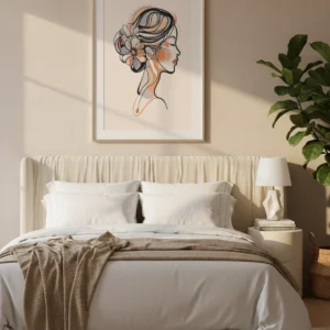 Affiche portrait femme floral encadrée clair, profil avec fleurs dans les cheveux, accrochée au-dessus d’un lit blanc dans une chambre lumineuse.