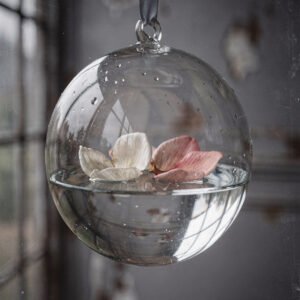 Affiche sphère en verre suspendue avec eau et pétales blanc et rose flottants ambiance minimaliste douce