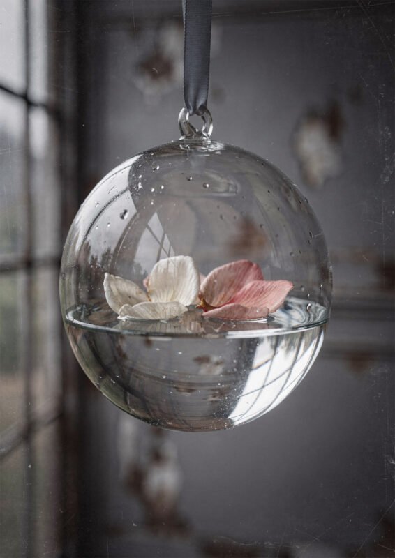 Affiche sphère en verre suspendue avec eau et pétales blanc et rose flottants ambiance minimaliste douce